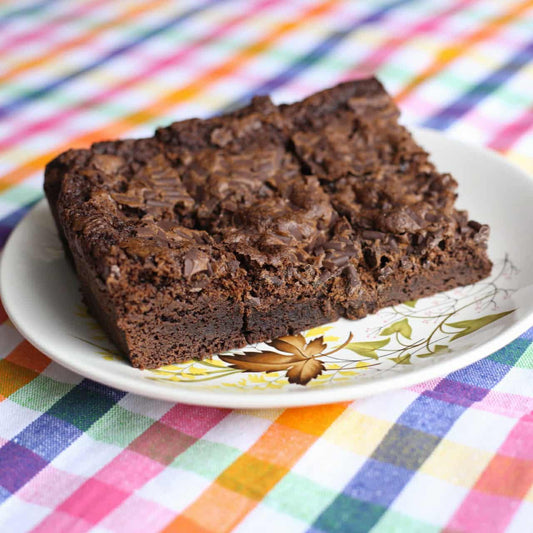 Chocolate brownie on a decorative plate with a colorful striped background